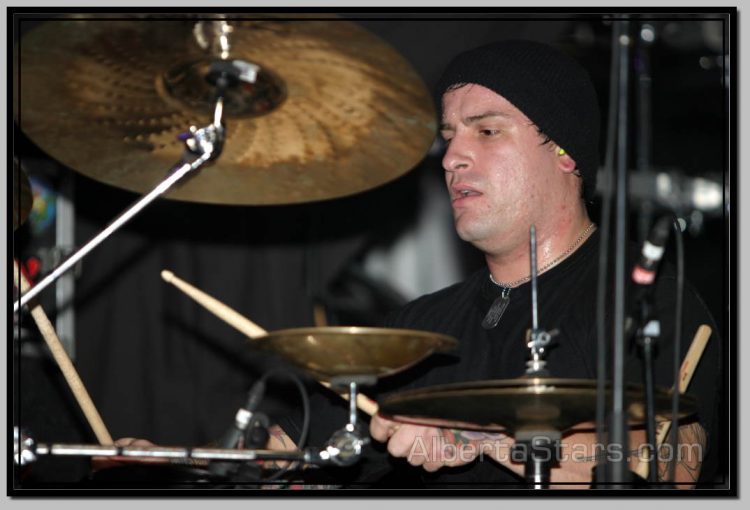 Derek Youngsma in Cap Behind Drumming Kit