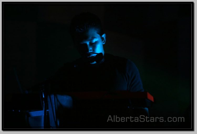 Blue Spot Light on Face of Imperative Reaction Keyboardist